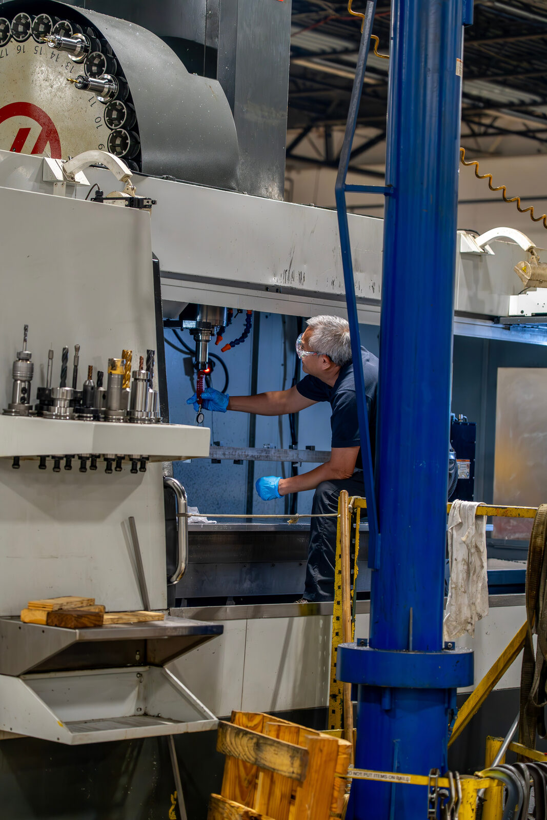 Machinist operating a five-axis mill for aerospace components