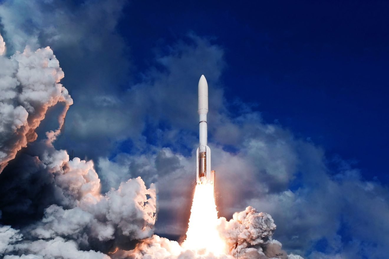 Launch vehicle ascending through exhaust clouds