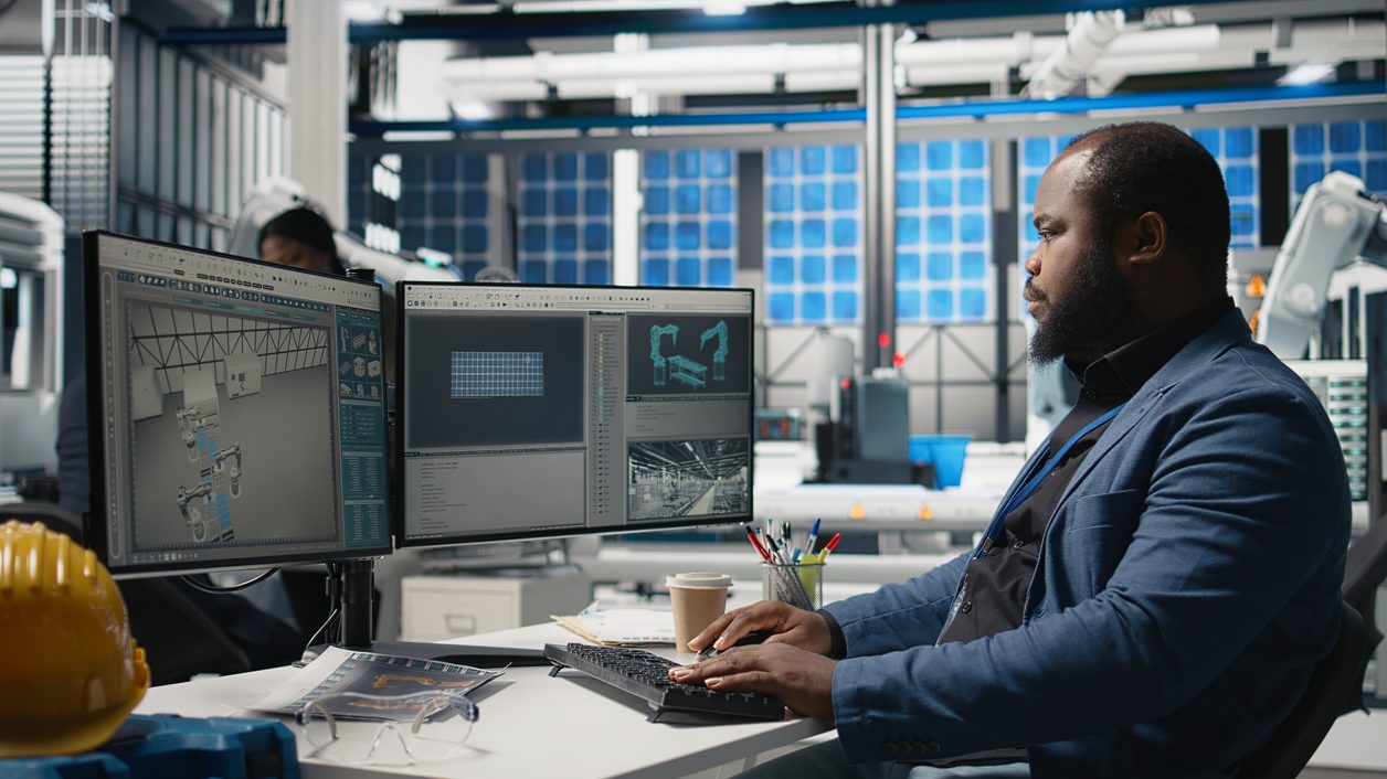 Machinist reviewing production documentation on the shop floor at a Compass Precision facility