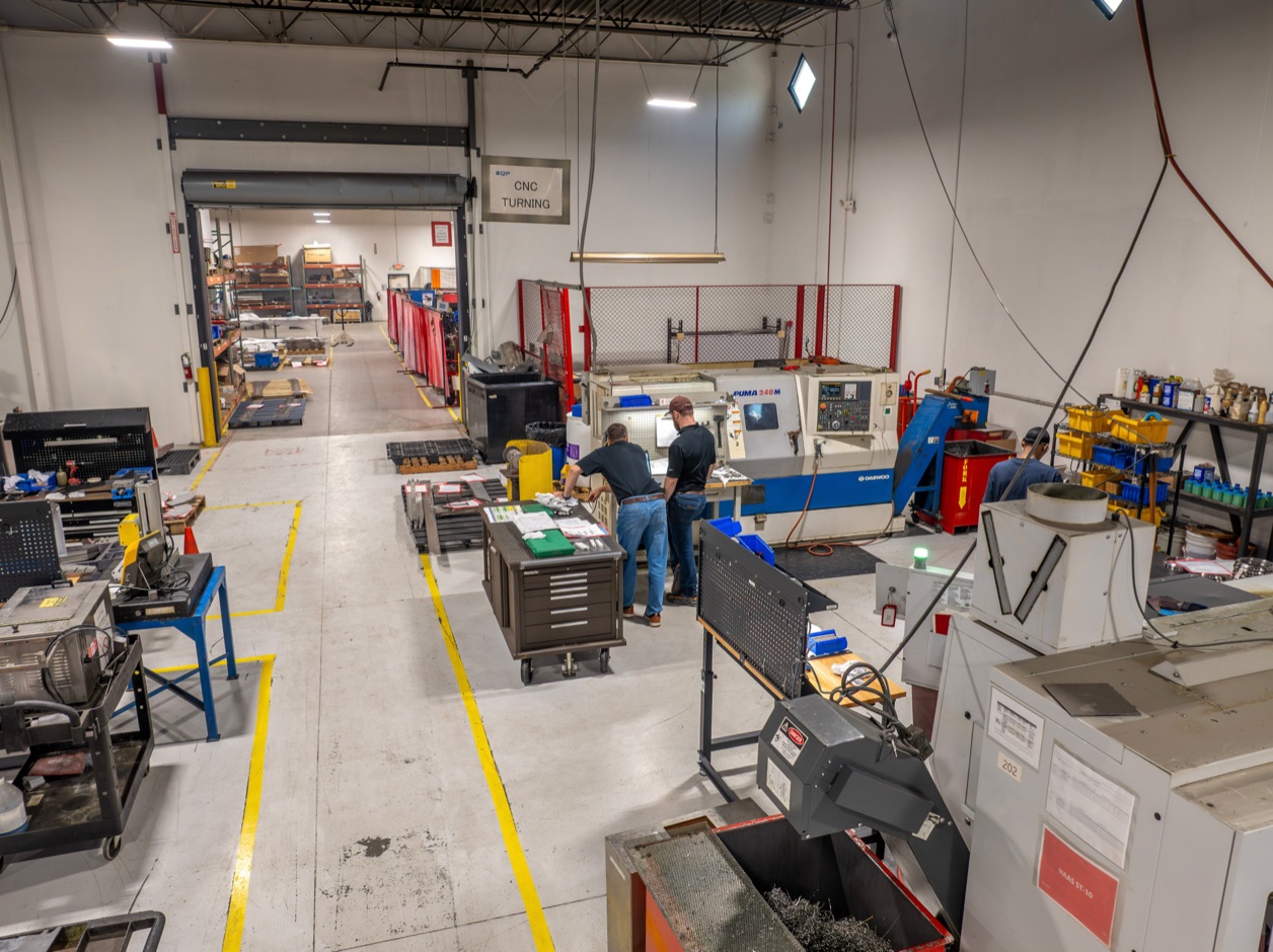 Production floor with CNC machines and staged material at a Compass Precision facility