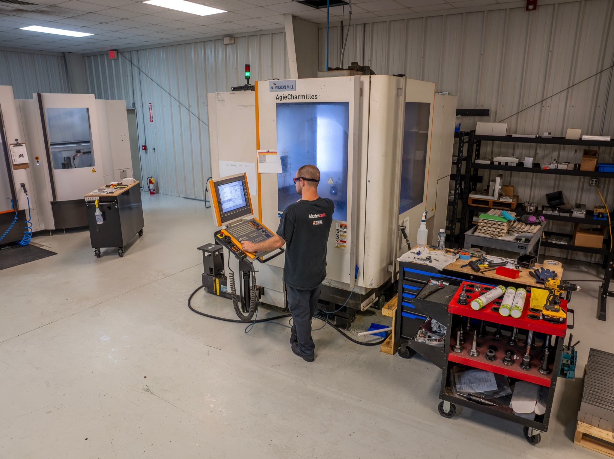 Machinist operating a multi-axis CNC machining center